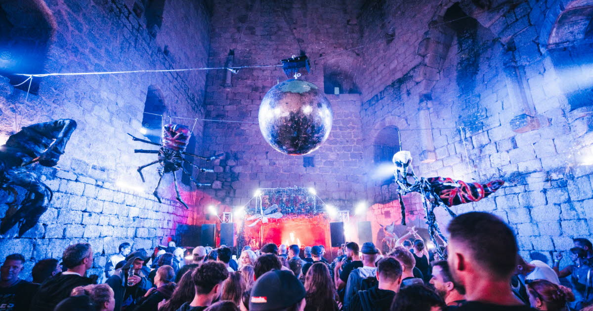 Le festival Envol : le public devant la scène, sous une boule à facettes, dans une enceinte de pierre